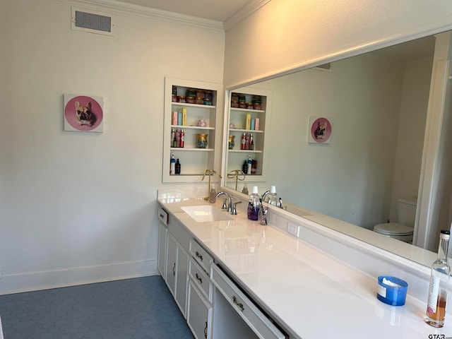 bathroom with toilet, vanity, and crown molding