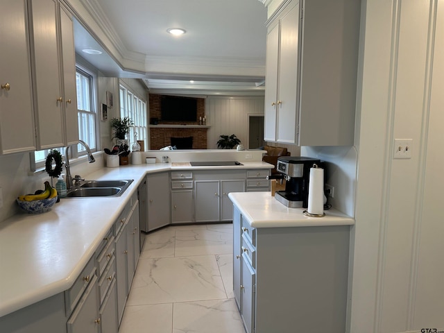 kitchen with gray cabinetry, a fireplace, crown molding, sink, and kitchen peninsula