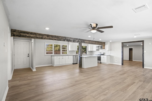 kitchen with white cabinetry, a kitchen island, stainless steel appliances, and light wood-type flooring