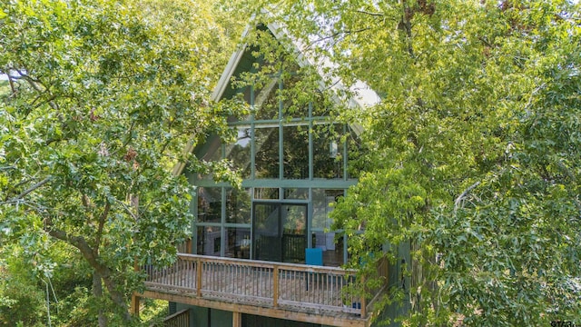 rear view of property with a deck and a sunroom