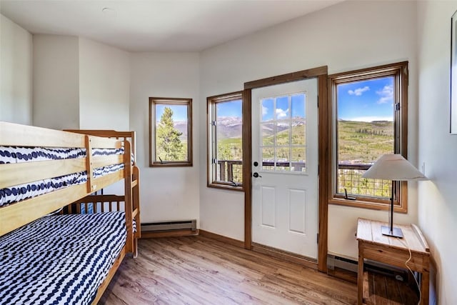 bedroom with baseboard heating and wood-type flooring