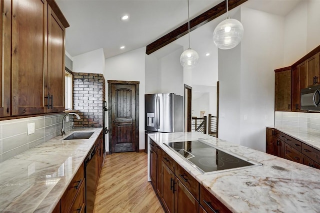 kitchen featuring sink, light stone counters, lofted ceiling with beams, decorative backsplash, and black appliances