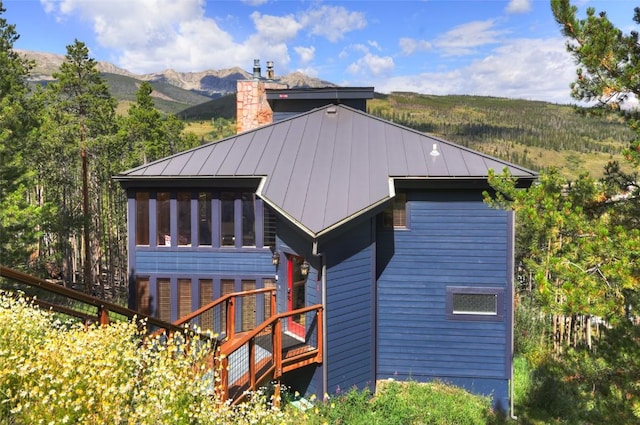 back of house featuring a mountain view and a sunroom