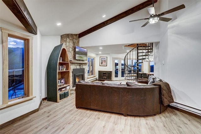 living room with a baseboard heating unit, a stone fireplace, vaulted ceiling with beams, ceiling fan, and light hardwood / wood-style floors