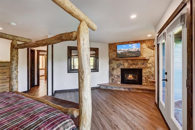 unfurnished bedroom featuring wood-type flooring and a stone fireplace