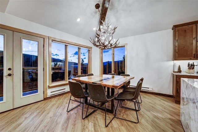 dining room with a notable chandelier, a mountain view, light wood-type flooring, and baseboard heating