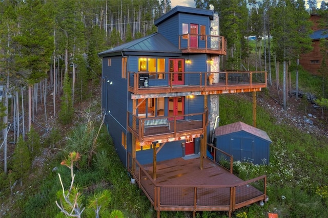 rear view of house featuring a storage shed, a deck, and a balcony