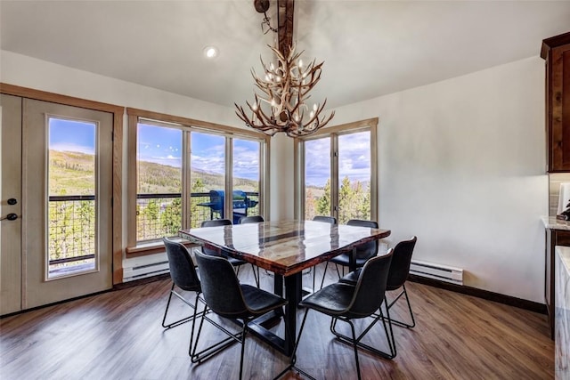 dining room featuring baseboard heating, an inviting chandelier, and hardwood / wood-style flooring