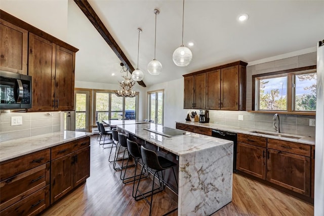 kitchen featuring decorative backsplash, a kitchen breakfast bar, sink, electric cooktop, and a center island