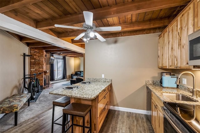 kitchen featuring beamed ceiling, dark hardwood / wood-style floors, a kitchen breakfast bar, and sink