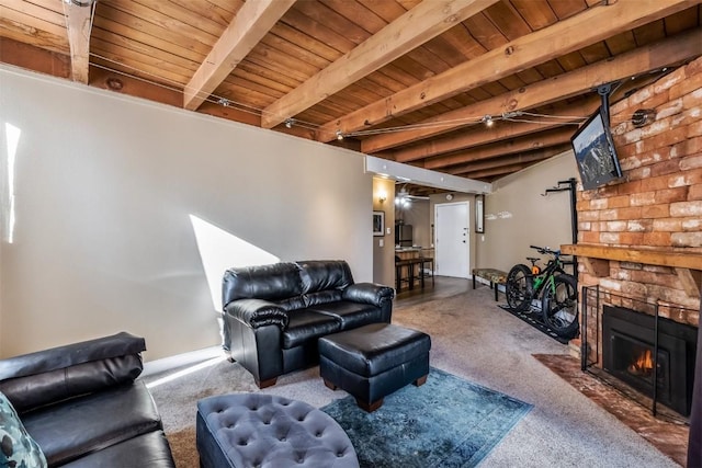 living room featuring a stone fireplace, beamed ceiling, and wood ceiling