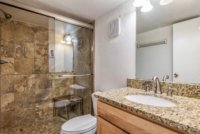 bathroom featuring an enclosed shower, vanity, and toilet