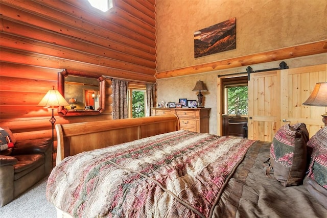 carpeted bedroom featuring a towering ceiling, a barn door, and rustic walls