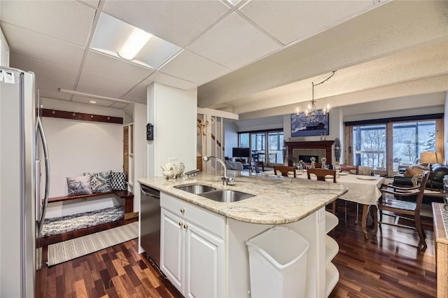 kitchen with white cabinets, appliances with stainless steel finishes, dark hardwood / wood-style floors, and sink