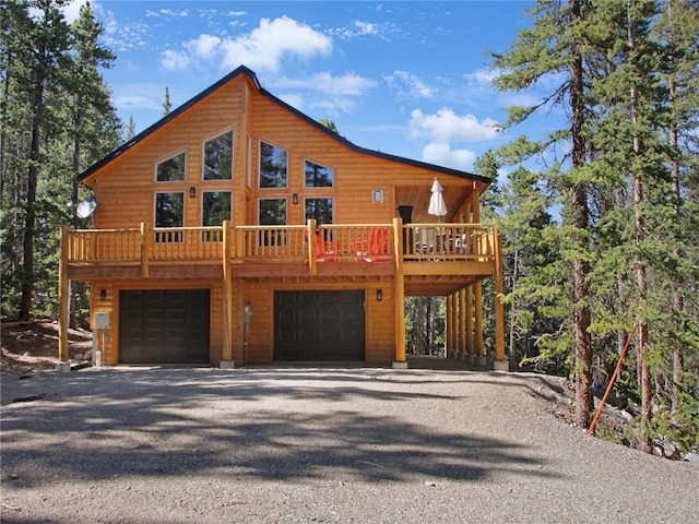 cabin featuring a garage and a wooden deck