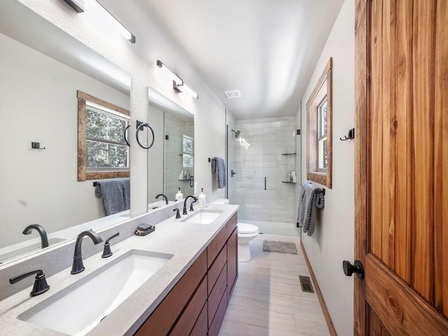 bathroom with an enclosed shower, vanity, and toilet