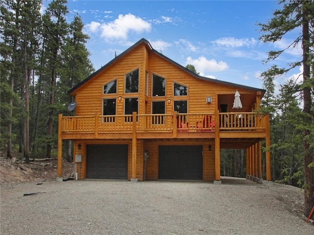 log home with a garage and a wooden deck