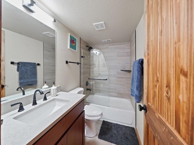 full bathroom featuring shower / bath combination with glass door, a textured ceiling, toilet, and vanity