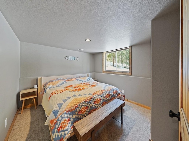 bedroom featuring a textured ceiling and dark colored carpet