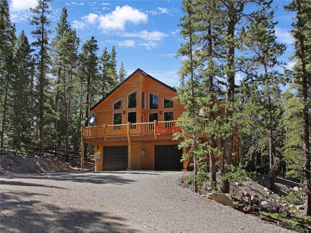 log cabin with a deck and a garage