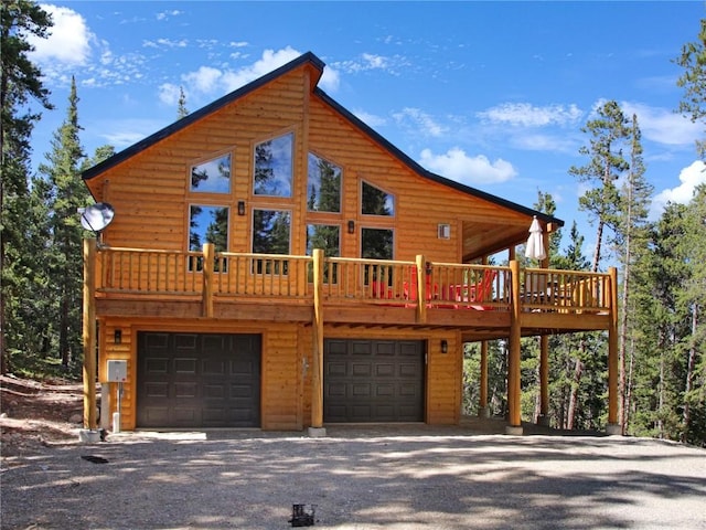 log cabin with a garage and a wooden deck