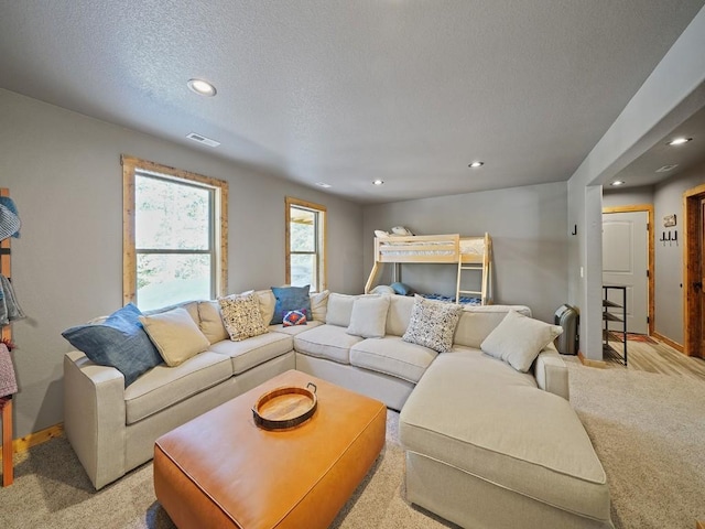 carpeted living room featuring a textured ceiling