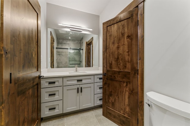 bathroom with vanity, toilet, and a shower with shower door