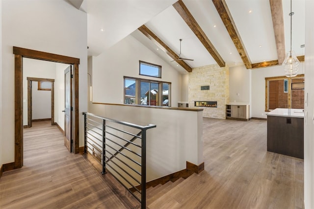 corridor featuring beam ceiling, wood-type flooring, and high vaulted ceiling