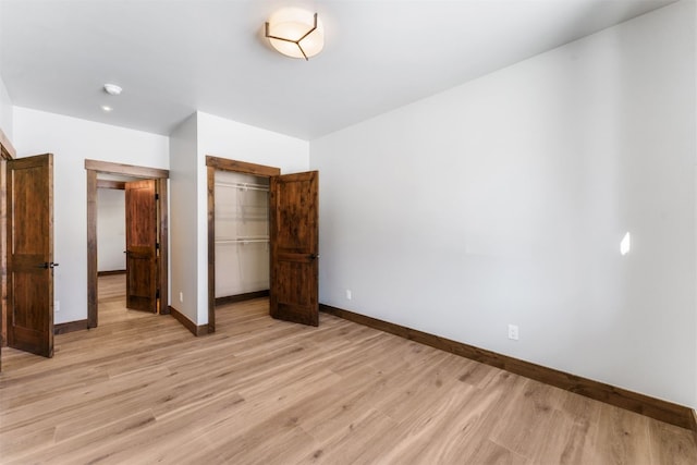 unfurnished bedroom with a closet and light wood-type flooring