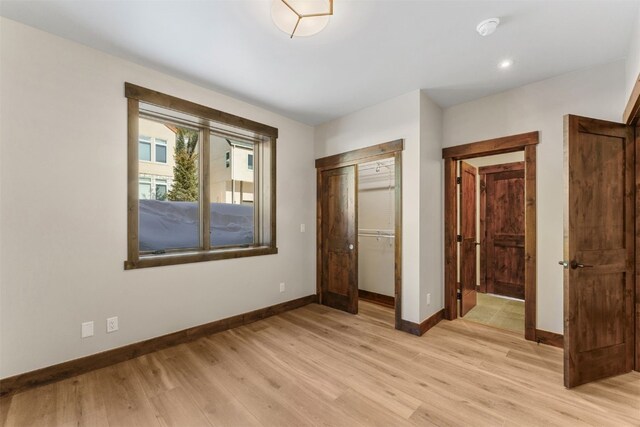 unfurnished bedroom featuring light wood-type flooring and a closet