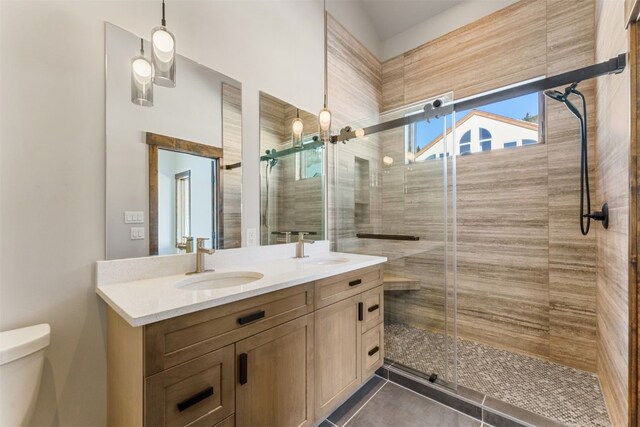 bathroom featuring tile patterned flooring, vanity, toilet, and a shower with door