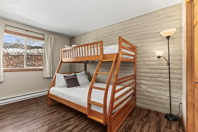 unfurnished bedroom featuring a baseboard heating unit, brick wall, and dark hardwood / wood-style floors