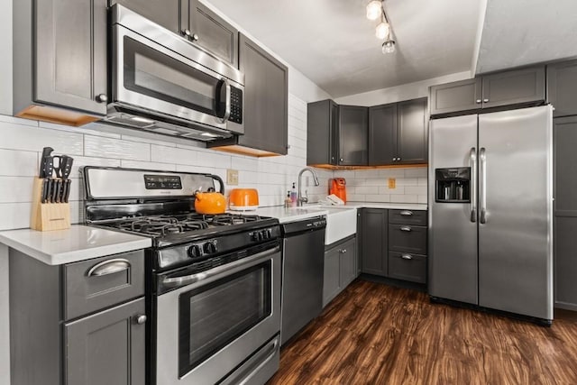 kitchen with dark wood-type flooring, stainless steel appliances, and gray cabinets