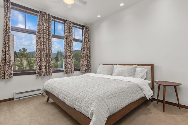 bedroom with carpet, multiple windows, and baseboard heating