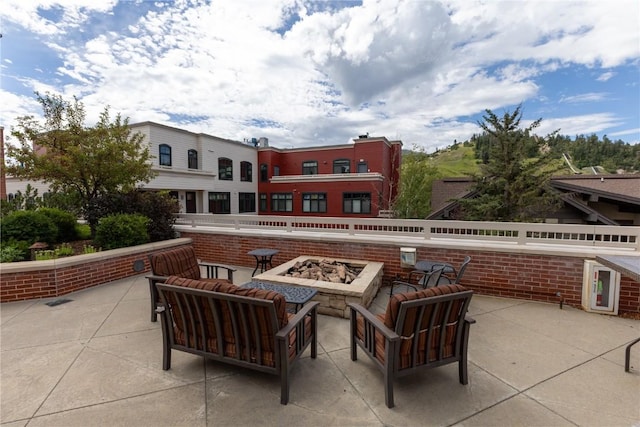 view of patio with an outdoor living space with a fire pit