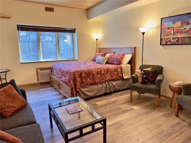 living room with wood-type flooring and an AC wall unit