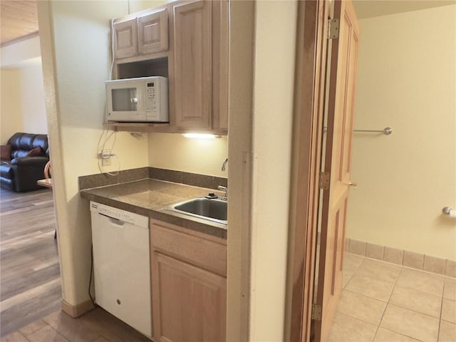 kitchen featuring sink, light brown cabinets, and white appliances