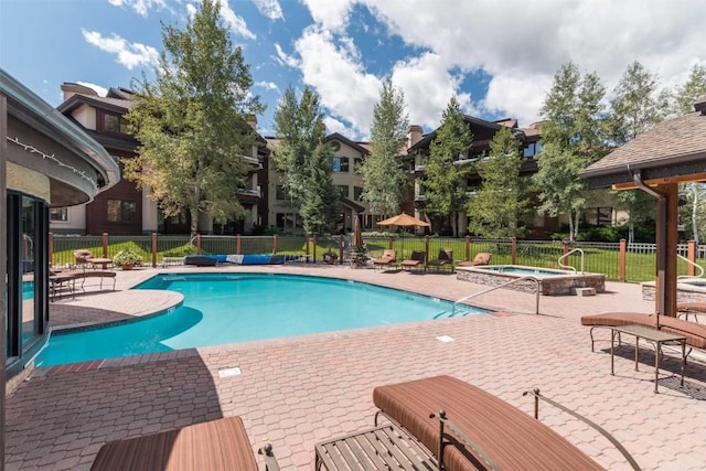 view of pool featuring a community hot tub and a patio area