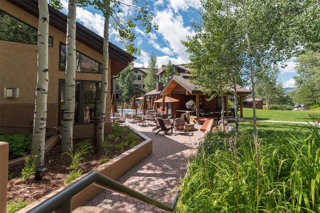 view of home's community with a lawn and a patio area