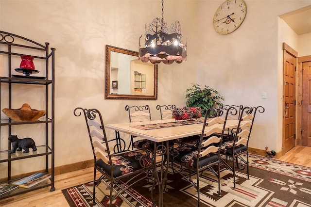 dining space featuring hardwood / wood-style flooring and a chandelier