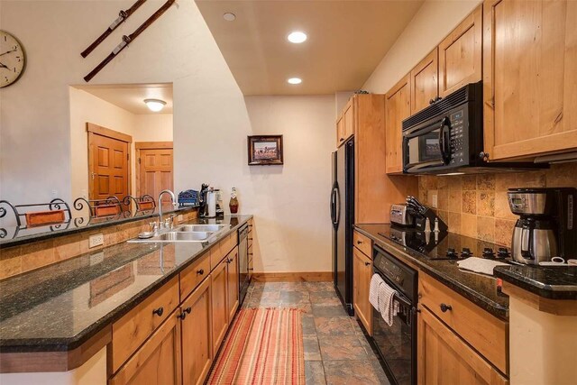 kitchen with kitchen peninsula, decorative backsplash, sink, black appliances, and dark stone countertops