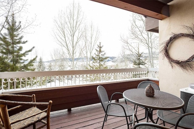 snow covered back of property with a mountain view and central AC