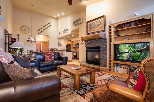 living room with built in shelves, a high ceiling, a wall mounted air conditioner, track lighting, and a fireplace