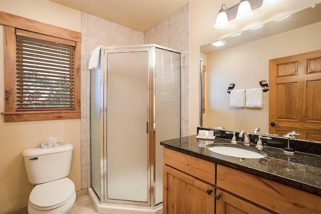 bathroom with tile patterned floors, vanity, toilet, and walk in shower