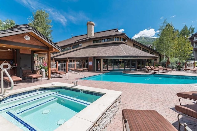 view of pool with a community hot tub and a patio