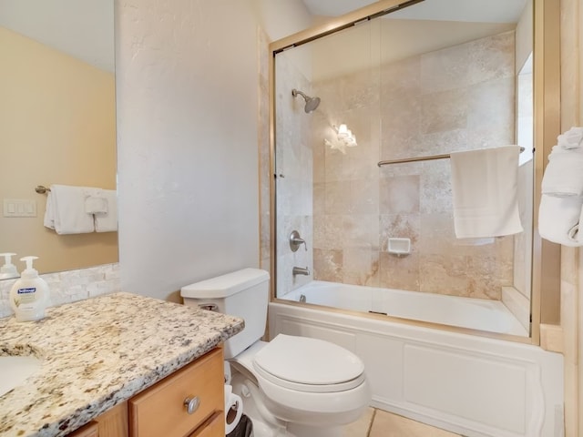 full bathroom with combined bath / shower with glass door, toilet, and vanity