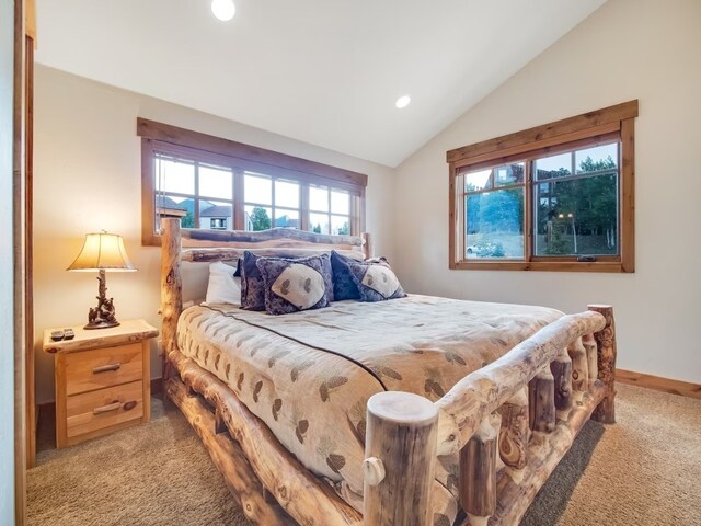 carpeted bedroom with lofted ceiling