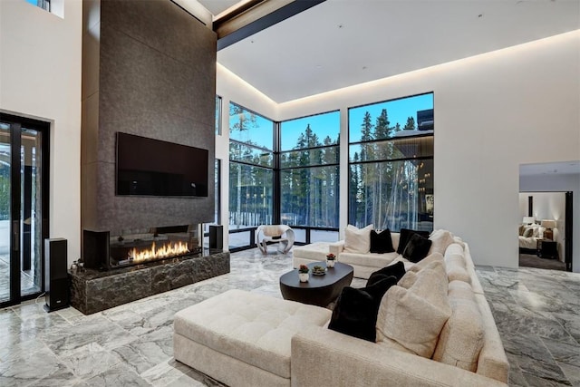 living room with a fireplace and a high ceiling