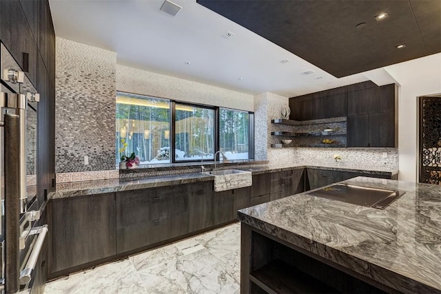 kitchen with decorative backsplash, black electric stovetop, dark brown cabinets, and dark stone countertops