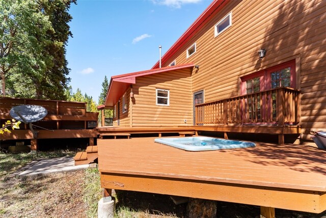 deck with an outdoor hot tub